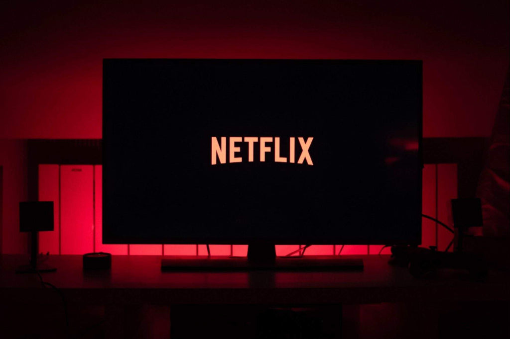Pantalla de televisor encendida con el logo de Netflix iluminado en rojo y fondo oscuro