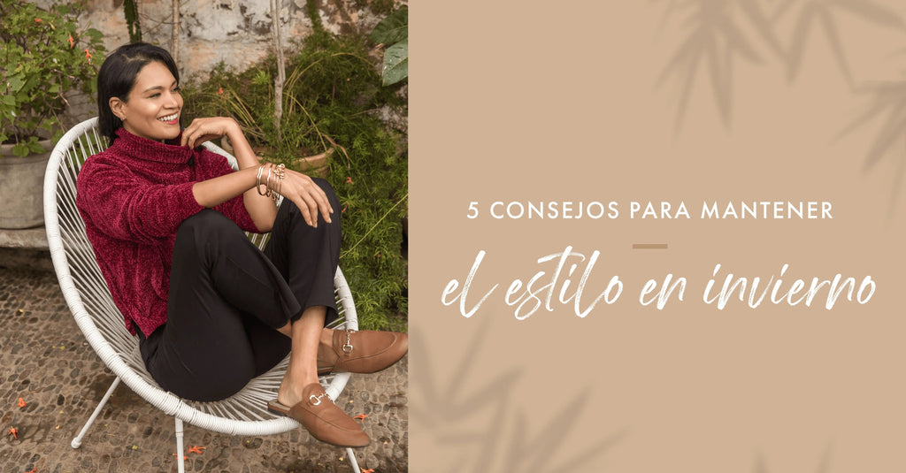 Mujer sonriente con suéter rojo y pantalones negros sentada en silla blanca en jardín, consejos de estilo invierno